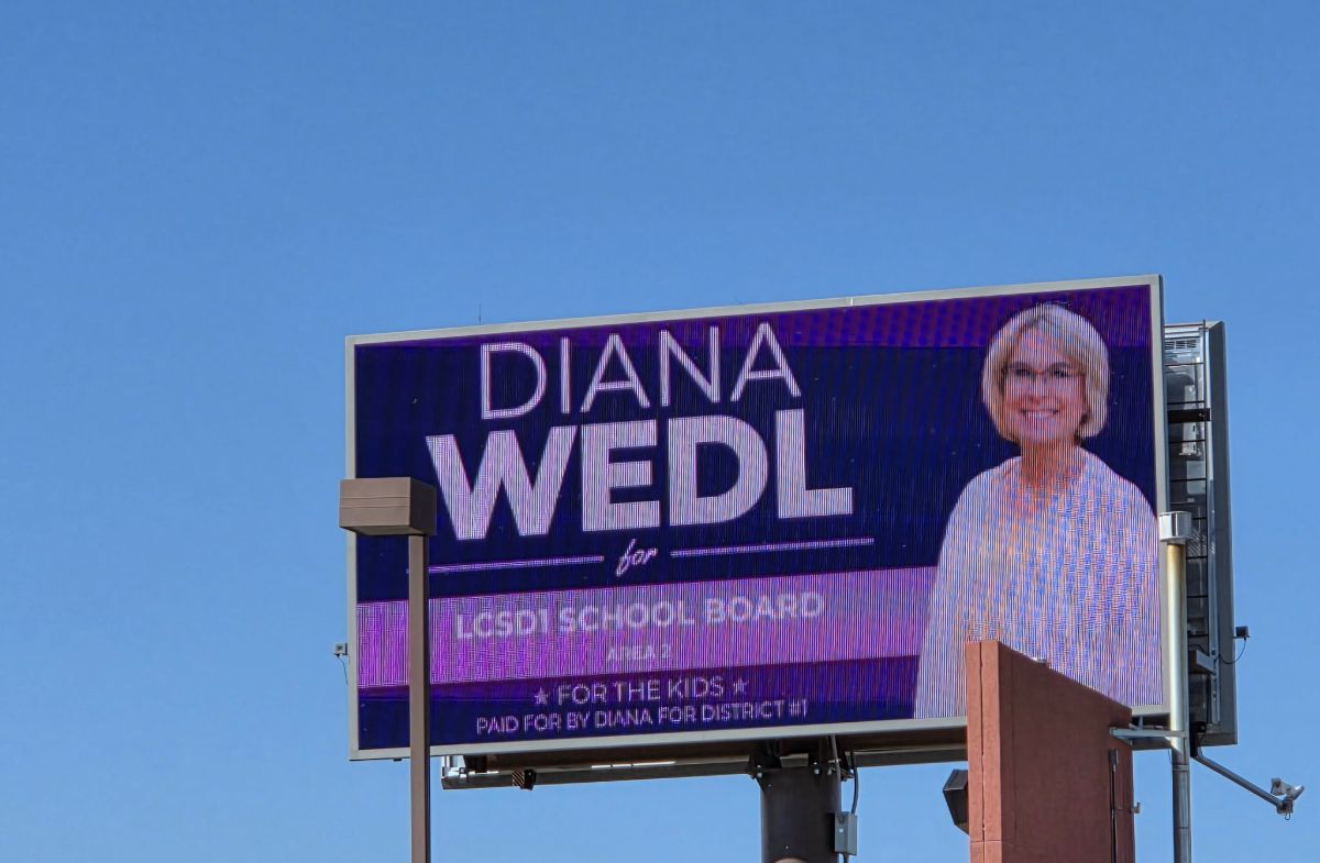 Diana's campaign billboard, lit up against a clear blue sky.