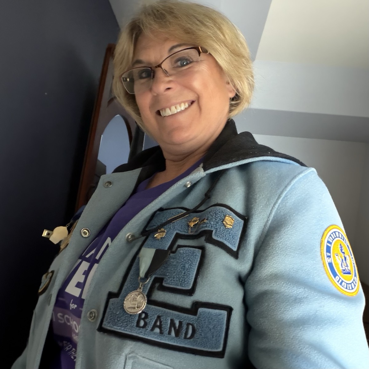 Diana smiling in her light blue East High band letter jacket, with a campaign shirt underneath.