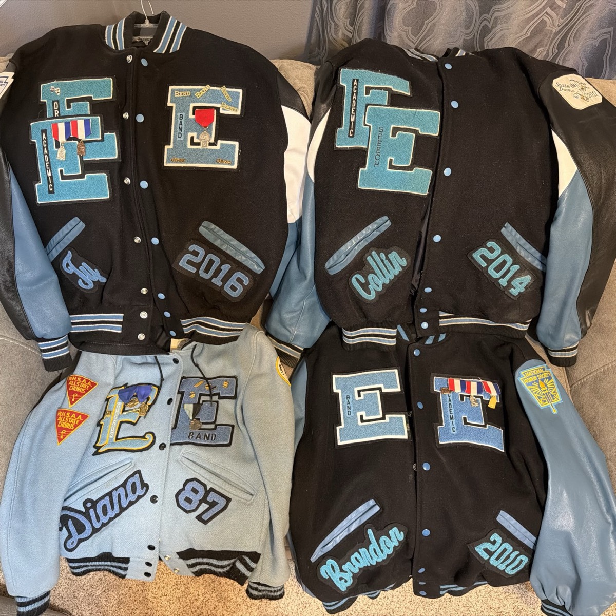 Four East High letter jackets laid out together, including Diana's light blue jacket from 1987.